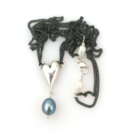 Billede af hele halskæden med hjerte i sølv og mørk perle og perledetalje ved låsen. Håndlavet af Christel Kaaber Guldsmedie