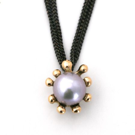 Søanemone halskæde i guld med grå perle set tæt på vedhænget med front. Designet og lavet af Christel Kaaber Guldsmedie