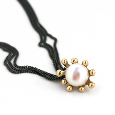 Søanemone halskæde i guld med hvid perle, her set liggende. Håndlavet af Christel Kaaber Guldsmedie